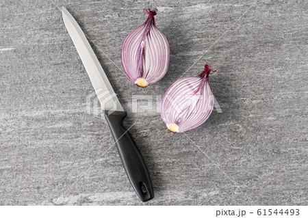 cut red onion and knife on slate stone background cut red onion and knife on slate stone background 61544493