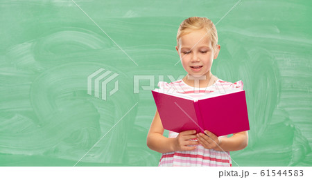 smiling little girl reading book at school 61544583