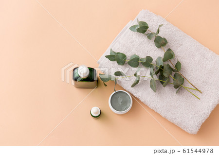 serum, clay mask, oil and eucalyptus on bath towel 61544978