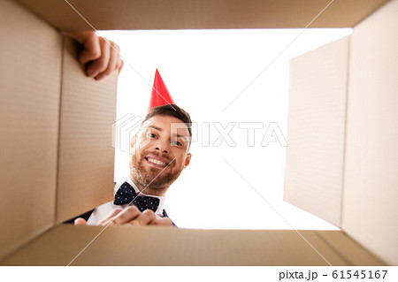 happy young man looking into open birthday gift happy young man looking into open birthday gift 61545167