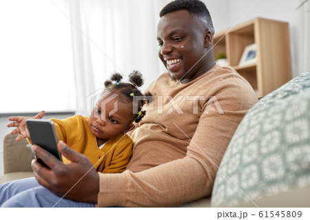 father with smartphone and baby daughter at home 61545809