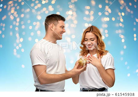 happy couple in white t-shirts with christmas gift happy couple in white t-shirts with christmas gift 61545938