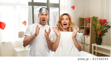 scared couple with eye sleeping mask and pillow 61546044