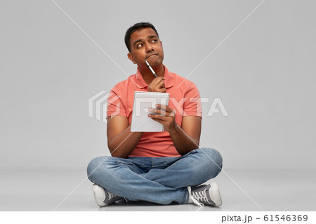 indian man in polo shirt with notebook and pen indian man in polo shirt with notebook and pen 61546369