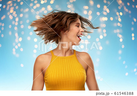 happy young woman shaking head over lights 61546388