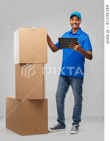 indian delivery man with tablet pc and boxes 61546389