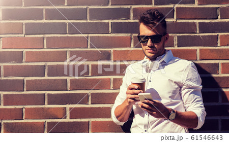 man with smartphone and coffee cup on city street man with smartphone and coffee cup on city street 61546643