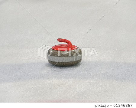 Curling rocks on a white and blue rink. 61546867