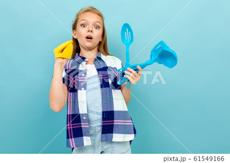 Teenager caucasian girl is going to cook something with kitchenware isolated on blue background Teenager caucasian girl is going to cook something with kitchenware isolated on blue background 61549166