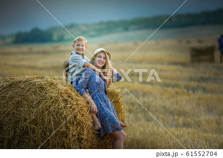 Mom and son close up in a field with mowed wheat 61552704