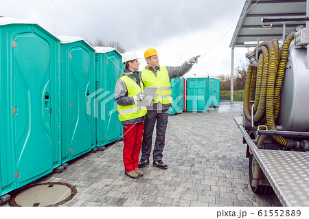 Workers inspecting mobile toilet before shipment 61552889
