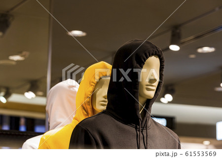 Two mannequin heads in a black and yellow hood. 61553569