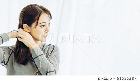 髪を結ぶ女性 61555287