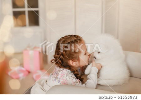 Little girl with white puppies and gift boxes 61555973