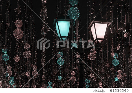 Metal lantern on background of shiny neon garlands. Festive occasions concept, holiday, Christmas, New Year backdrop Metal lantern on background of shiny neon garlands. Festive occasions concept, holiday, Christmas, New Year backdrop 61556549