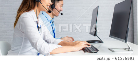 Call center agents using computers working in office 61556993
