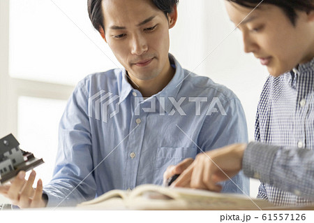 一級建築士の学科試験対策で法令集を引きながら建築基準法を学ぶ男性二人 61557126