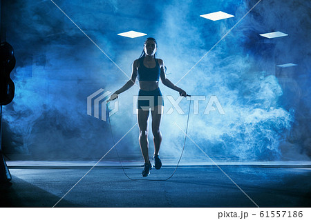Athletic woman using skipping rope. 61557186