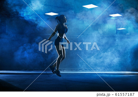 Athletic woman using skipping rope. 61557187