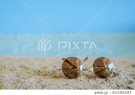 Sunglasses eyeware drop on tropical sand beach. 61560385