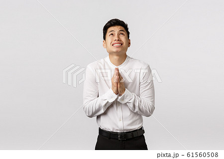Worried and inescure young asian guy in forma outfit, clasp hands together in pray near chest, look up sky, begging god, supplicating, put effort to hope everything be okay, ask please Worried and inescure young asian guy in forma outfit, clasp hands together in pray near chest, look up sky, begging god, supplicating, put effort to hope everything be okay, ask please 61560508