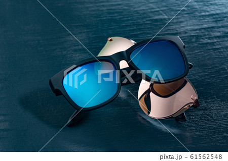 Two fashionable sunglasses on a blue background. Two fashionable sunglasses on a blue background. 61562548
