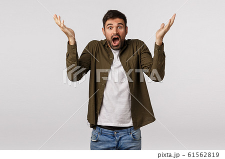 Shocked and embarrassed, bearded man panicking, raise hands up sideways puzzled and confused, feeling frustrated and speechless, gasping stare camera troubled, faced strange situation Shocked and embarrassed, bearded man panicking, raise hands up sideways puzzled and confused, feeling frustrated and speechless, gasping stare camera troubled, faced strange situation 61562819