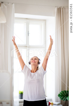 Young woman with headphones in bedroom indoors at home. Young woman with headphones in bedroom indoors at home. 61563561