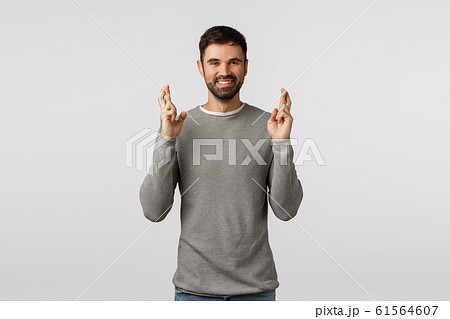 Anticipation, hope and emotions concept. Cheerful faithful good-looking bearded guy feeling lucky, cross fingers good fortune and smiling, expect good news, ancitipate win, standing white background Anticipation, hope and emotions concept. Cheerful faithful good-looking bearded guy feeling lucky, cross fingers good fortune and smiling, expect good news, ancitipate win, standing white background 61564607