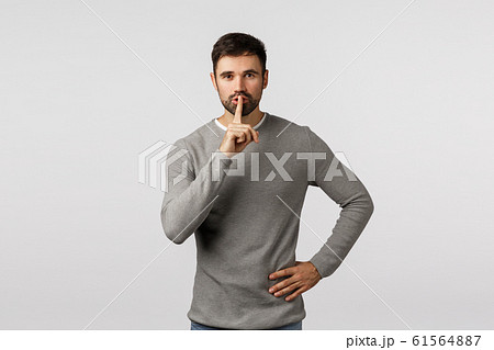 Shhh, its secret. dont tell anyone. Mysterious charming and kind young bearded dad asking keep quiet, shushing with index finger pressed to lips, seal mouth, tell be silent, white background 61564887