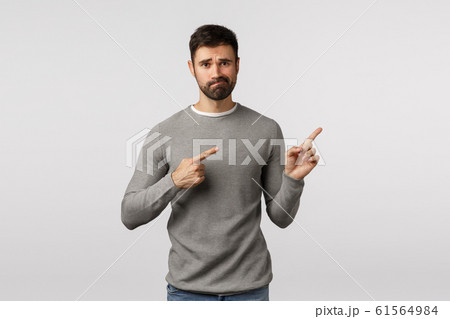 Guy trying say bad news, pointing upper right corner with regret and disappointment. Handsome bearded husband indicating promo upset and skeptical, smirk look distressed or unsatisfied 61564984