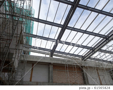 Lightweight roof trusses under construction at the construction site. Installed properly by workers to received the roof covering system.  61565828