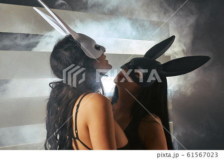 Sexy brunette masked rabbits kiss. LGBTQ concept, Girls in sexy outfits on the background of bright flashes of neon light. Fetish. Sexy woman in a boudoir. BDSM Sexual games of two girls. Sexy brunette masked rabbits kiss. LGBTQ concept, Girls in sexy outfits on the background of bright flashes of neon light. Fetish. Sexy woman in a boudoir. BDSM Sexual games of two girls. 61567023