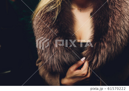 Decollete, female breast. Neckline green dress and fur collar. Decollete, female breast. Neckline green dress and fur collar. 61570222
