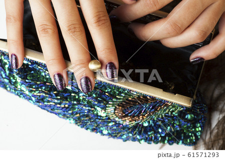 woman hands with shiny manicure holding little purse peacok feather, cosmetic and fashion people concept 61571293