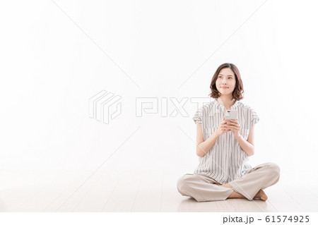 若い女性　座る　床　胡座　スマートフォン 61574925
