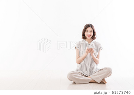 若い女性　座る　床　胡座　スマートフォン 61575740