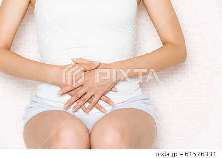 お腹をおさえる女性. お腹をおさえる女性. 61576331