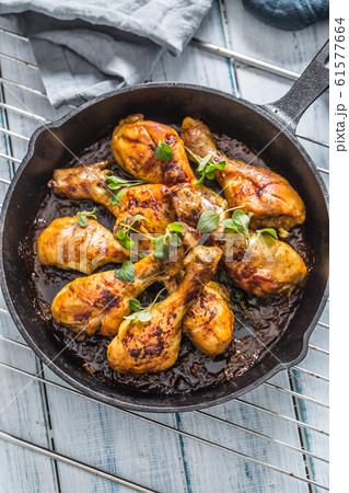 Roasted chicken legs in pan with herbs - close up 61577664