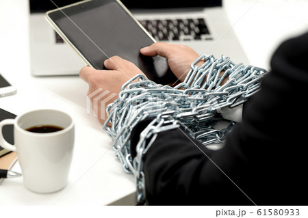 鎖に拘束されながらタブレットを持つビジネスマン 61580933