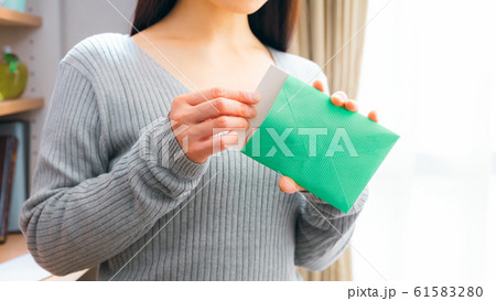 郵便物を開封する女性 61583280