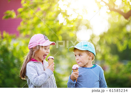 Happy child eating ice cream outdoors in summer 61585234