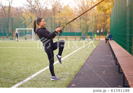 Girl athlete functional training on sportground. Girl athlete functional training on sportground. 61591186