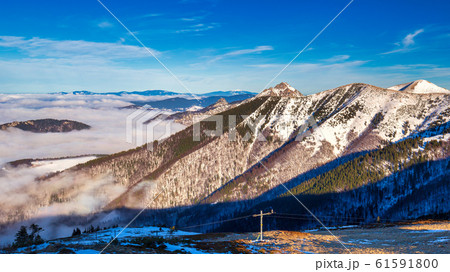Winter mountain landscape at a sunny day with fog Winter mountain landscape at a sunny day with fog 61591800