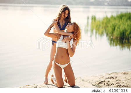 Sporty mother with cute daughter walking near lake Sporty mother with cute daughter walking near lake 61594538