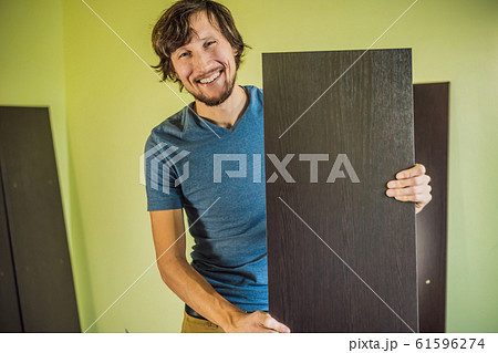 Frustrated Man Putting Together Self Assembly Furniture Frustrated Man Putting Together Self Assembly Furniture 61596274
