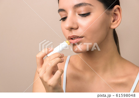 lips care and protection. woman applying balm on lips 61598048