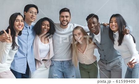 Portrait of happy young business team posing over grey background Portrait of happy young business team posing over grey background 61599400