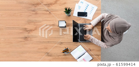 Top view of islamic woman working on laptop at workplace 61599414