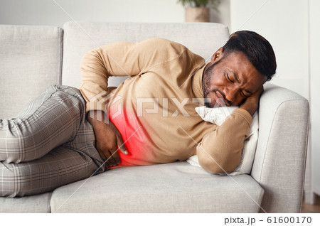 Guy Touching Stomach Red Pain Zone Lying On Sofa 61600170